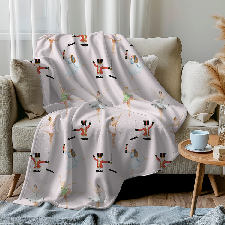 A pink Nutcracker themed minky blanket, draped over a sofa in a living room setting.