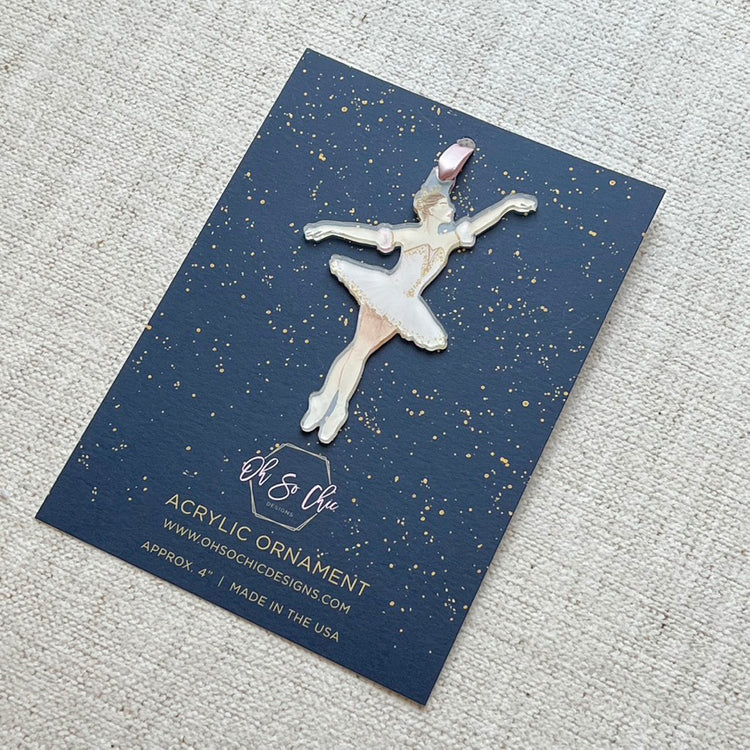 An ornament featuring the Sugarplum Fairy ballerina from Nutcracker in her pink tutu on a blue card backer
