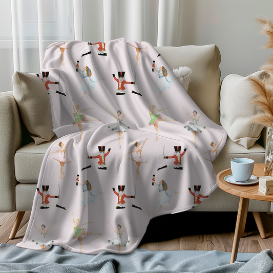 A pink Nutcracker themed minky blanket, draped over a sofa in a living room setting.