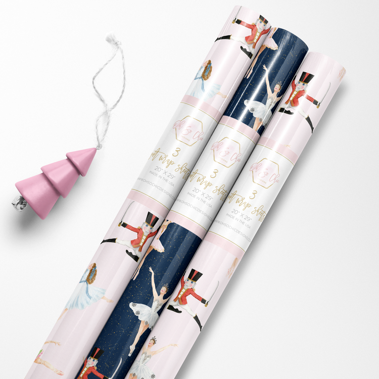 Rolls of pink and navy blue luxury wrapping paper with Nutcracker ballet characters.